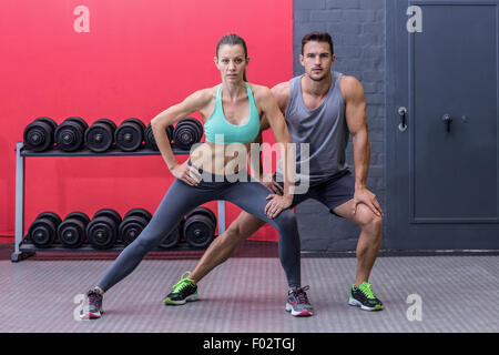 Muscular couple doing leg stretchings Stock Photo