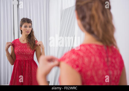 Woman trying on a red dress Stock Photo