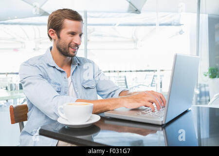 Young happy man typing on the laptop Stock Photo
