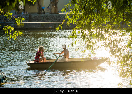 People in car-shaped paddle boats in Vltava River with Charles bridge and Novotneho lavka in background, Prague, Czech Republic Stock Photo