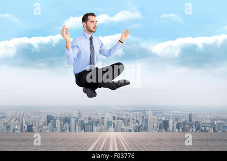 Composite image of relaxed businessman sitting in lotus pose Stock Photo