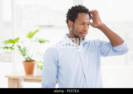 Young thinking businessman scratching his head Stock Photo