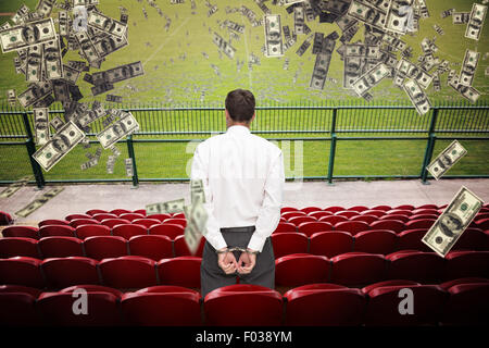 Composite image of rear view of young businessman wearing handcuffs Stock Photo