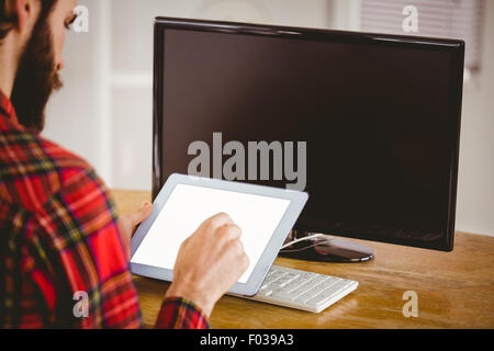 Hipster businessman working on his tablet pc Stock Photo