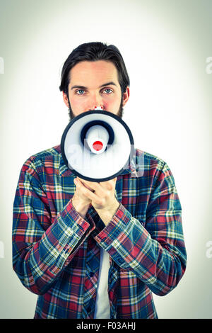 Handsome hipster shouting through megaphone Stock Photo
