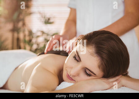 Young woman getting a hot stone massage Stock Photo