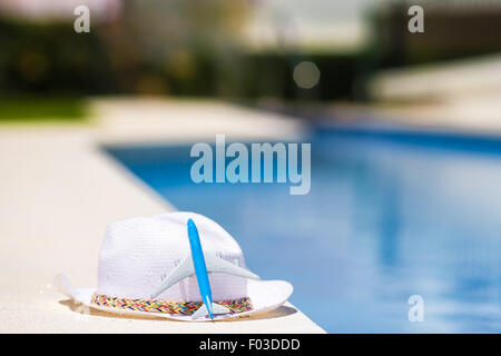 Aircraft model and straw purple hat near swimming pool at summer Stock ...