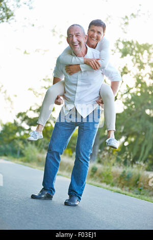 Happy senior couple having fun together in summer in nature Stock Photo