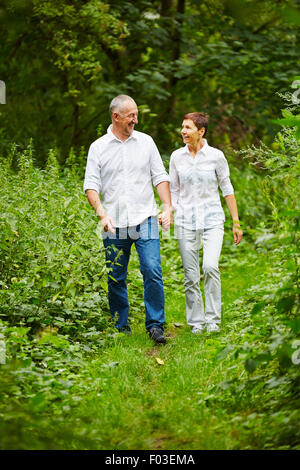 Happy senior couple taking a walk in nature in summer Stock Photo