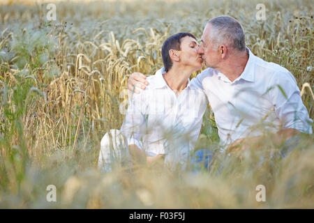 Senior couple in love kissing in a wheat field Stock Photo