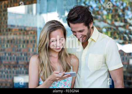 Smiling couple looking at smartphone Stock Photo