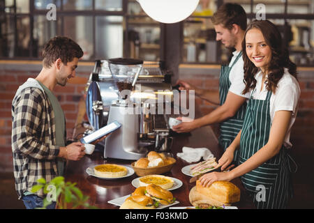 Smiling waiters serving a client Stock Photo