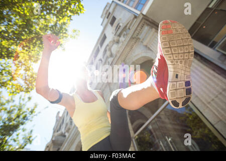 A pretty woman jumping in the street Stock Photo