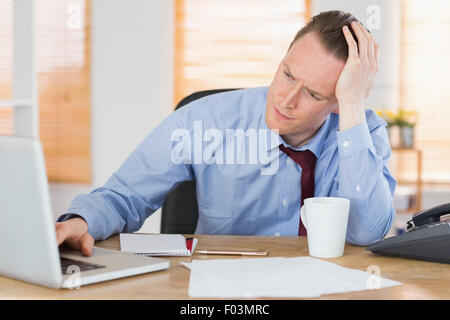Stressed businessman working at his desk Stock Photo