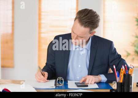 Concentrated businessman writing down Stock Photo - Alamy