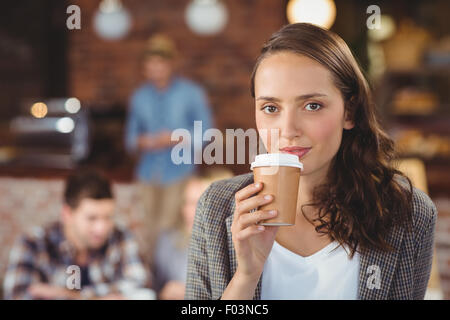 Smiling young woman drinking from take-away cup Stock Photo