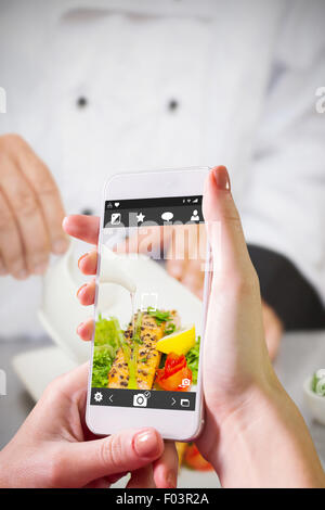 Composite image of hand holding smartphone Stock Photo