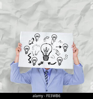 Composite image of portrait of a businessman hiding his face behind a blank panel Stock Photo