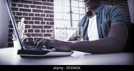 Casual businessman working on laptop at desk Stock Photo