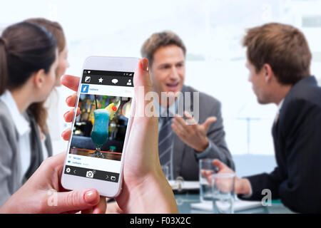 Composite image of hand holding smartphone Stock Photo