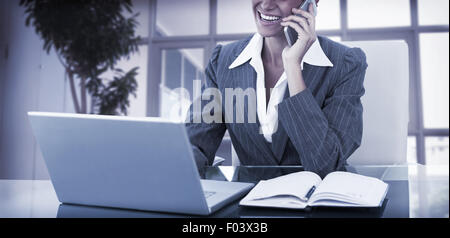 Businesswoman on call and using her laptop Stock Photo