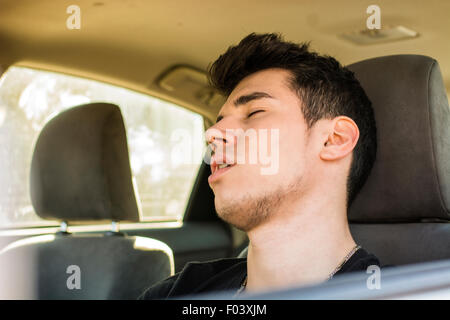 Handsome young man sleeping at the wheel driving his car. Danger concept Stock Photo