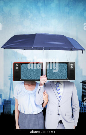 Composite image of business people holding a black umbrella Stock Photo