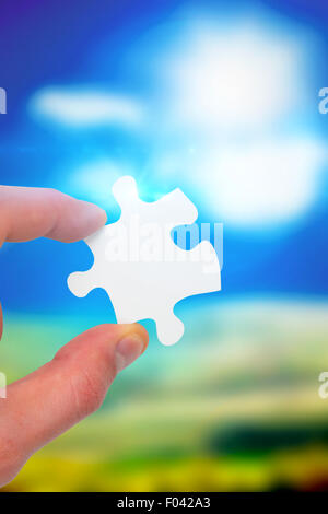 Composite image of hand holding jigsaw piece Stock Photo - Alamy