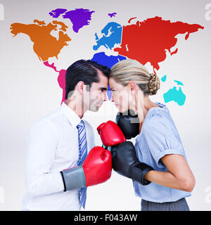 Composite image of business people wearing and boxing red gloves Stock Photo