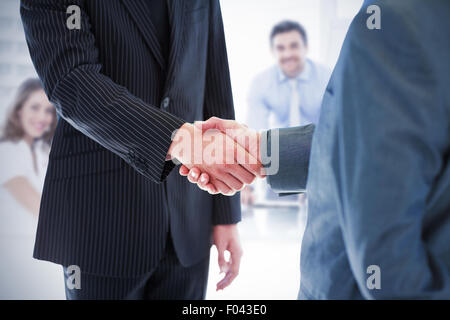 Composite image of business people shaking hands Stock Photo