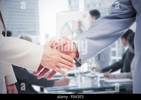Composite image of close up of business people shaking their hands Stock Photo