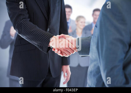 Composite image of business people shaking hands Stock Photo