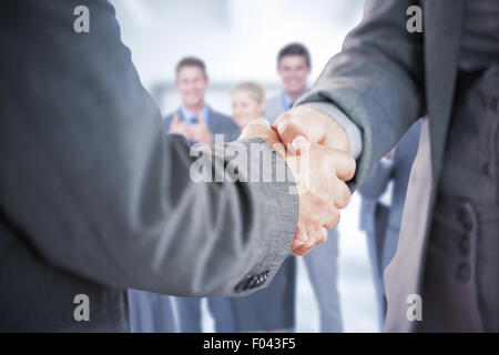 Composite image of business people shaking hands close up Stock Photo