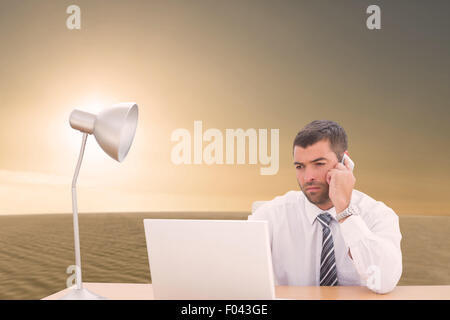 Composite image of businessman using laptop at desk Stock Photo