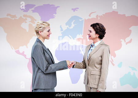 Composite image of  smiling women shaking hands Stock Photo