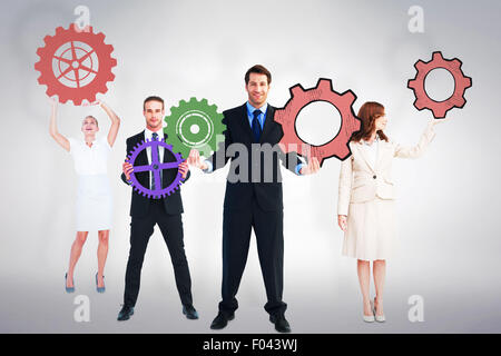 Composite image of business people holding cogs Stock Photo