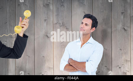 Composite image of handsome man standing with arms crossed Stock Photo