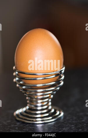 A Boiled Egg in a spiral silver egg cup holder Stock Photo