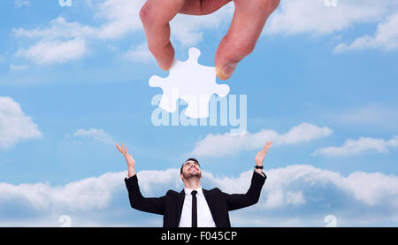 Composite image of hand holding jigsaw piece Stock Photo