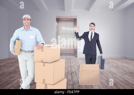Composite image of handsome delivery man leaning on stacked cardboard boxes Stock Photo