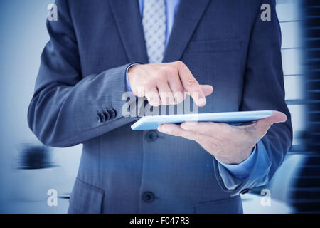 Composite image of businessman using tablet pc Stock Photo
