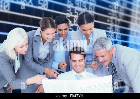 Composite image of happy business people looking at newspaper Stock Photo