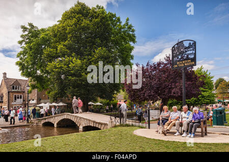 Tourists enjoy summer afternoon in the Cotswold village of Bourton-on-the-Water, Gloucestershire, England. Stock Photo