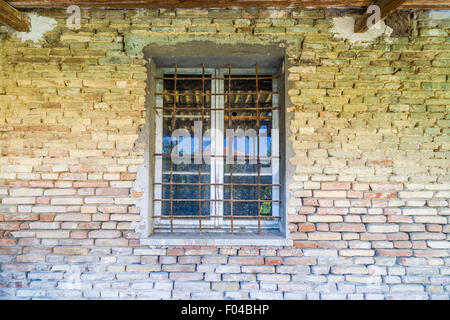 iron bars window in dilapidated brick wall Stock Photo