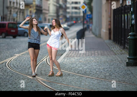 Funny teen girls together walking on the pavement on the street. Stock Photo