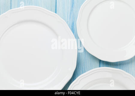 Empty plates over wooden table background. View from above with copy space Stock Photo
