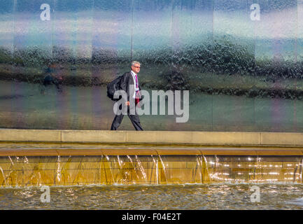 Business man in suit in front of water features, Sheffield railway station, South Yorkshire Stock Photo