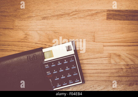 HP-12C Hewlett-Packard rpn financial calculator with slipcase on a natural wood table top background Stock Photo