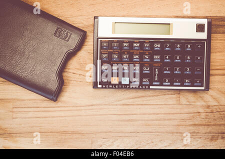 HP-12C Hewlett-Packard rpn financial calculator with slipcase on a natural wood table top background Stock Photo