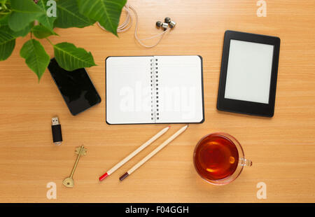 Office table with notepad, tea cup , pen , smartphone , headphone, tablet. View from above Stock Photo